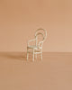 The Maileg Vintage Chair, Mouse Size - Off White is a small, white metal chair with a rounded backrest, ideal for mouse-sized furniture collections. Shown on a light brown surface with a beige background.