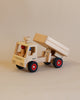 A handcrafted Fagus Wooden Dump Truck with red wheels and a movable dump bed, displayed on a plain background.