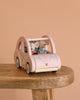 Two small plush mice in striped shirts sit inside the Maileg Road Trip Adventure Set’s wooden toy car with floral details, arranged on a wooden table against a peach backdrop—a delightful addition to any dolls house.