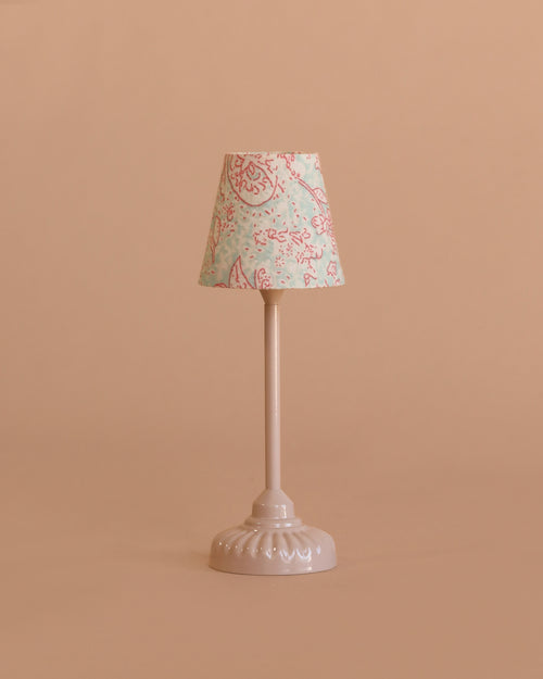 The Maileg Vintage Floor Lamp, Mouse - Powder features a white ornate base and a pastel pink and blue floral lampshade, perfect for dollhouse decor, shown against a plain beige background.