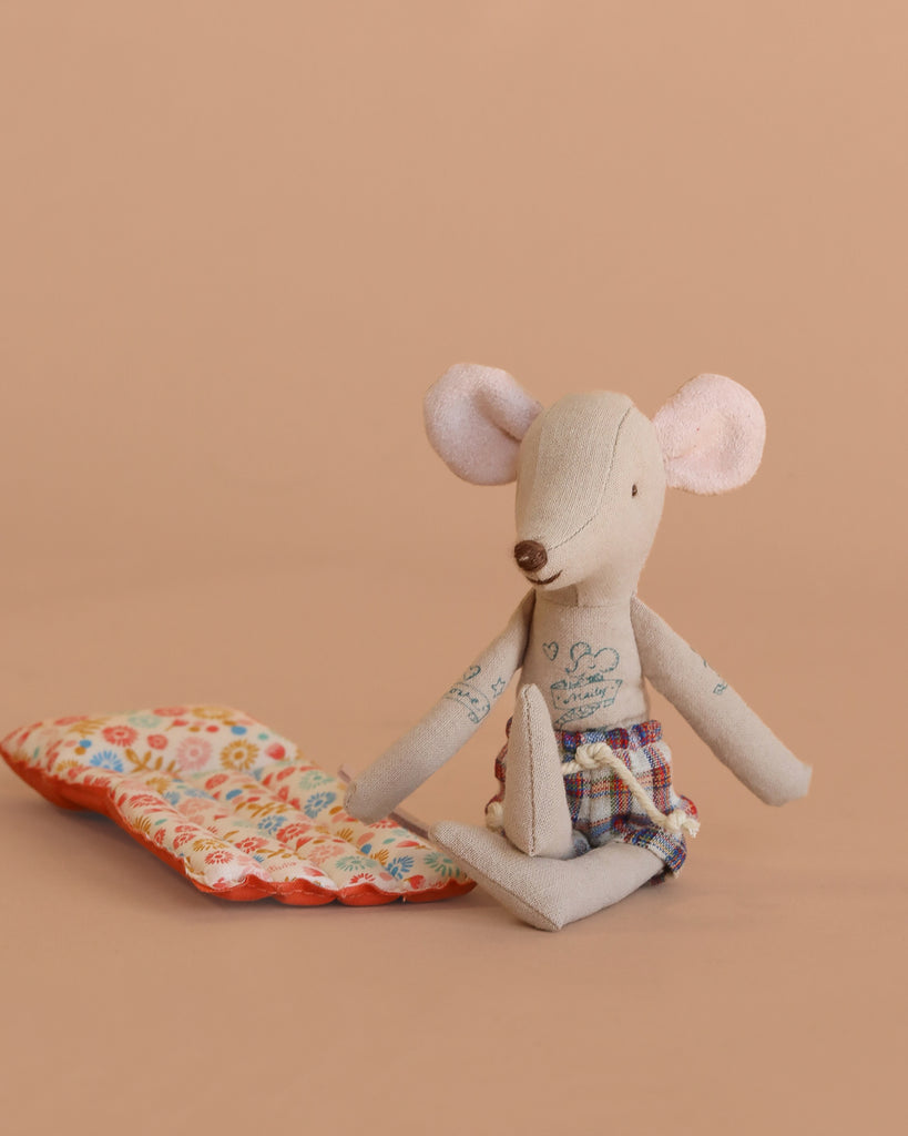 The Maileg Beach Mouse with Air Mattress - Dad wears plaid shorts and sits beside his air mattress on a plain beige background, ready for a cozy summer set—no extra bedding needed.