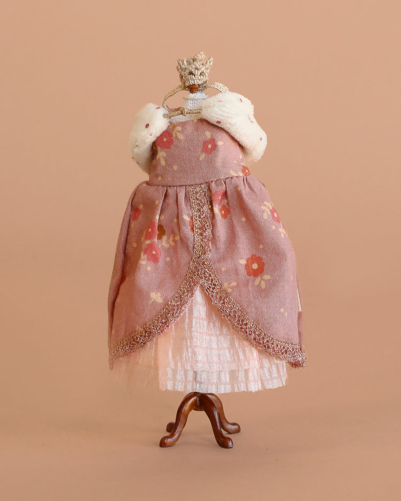 A headless dress mannequin displays the Maileg Queen Dress, Mum Mouse: a pink floral princess dress with white lacy skirt, faux fur stole, and jeweled crown—ideal inspiration for doll or mouse accessories on a plain beige background.