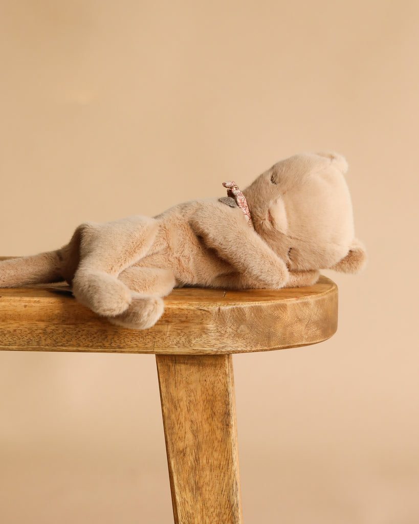 The Maileg Small Sleeping Kitten in Basket features a light brown plush kitten with a patterned collar, lying on its side—ideal for pairing with other Maileg accessories or displaying in a pet basket.
