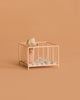 A small toy mouse in pink pajamas stands inside the Maileg Playpen, My - Rose, with a blue-patterned blanket, set against a plain beige background.