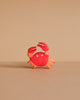 A small, red and orange cartoon crab with two raised claws and wide eyes stands on a light brown surface—just like the handcrafted Holztiger Crab, made in Europe and ships in one week.