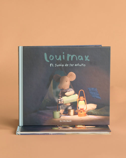 Spanish: Maileg LouiMax - El Sueño de Ser Adulto" is an illustrated Spanish children’s book about LouiMax the mouse, who holds a flashlight and sits by a lantern under a tent.