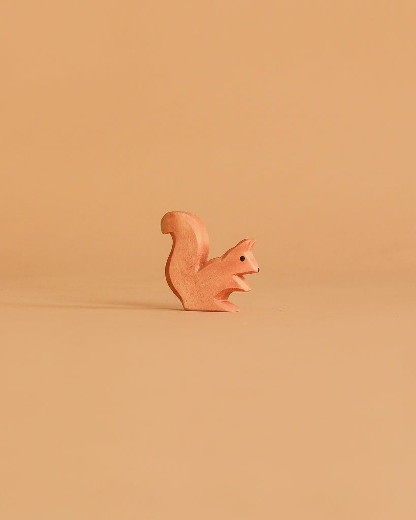 The Ostheimer Handmade Wooden Woodland Set features a small, minimalist wooden squirrel figurine displayed on a plain, light brown background—an elegant example of handcrafted toys made from sustainable materials.