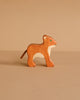 A handcrafted Holztiger Handmade Wooden Safari Animals Set lion cub figurine standing in profile.