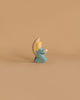 Ostheimer Little Angel - Turquoise: This wooden figurine features an angel with blond hair, donned in a turquoise robe and white wings, kneeling with hands clasped. Handcrafted from sustainably sourced materials, the piece embodies the timeless quality characteristic of Ostheimer wooden toys. The background is plain white.