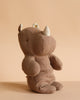 The Maileg Small Rhino - Chocolate, crafted from soft fabric and recycled polyester, sits upright on a neutral beige background—perfect for joining your Safari friends collection.