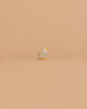 The Ostheimer Bird - Bald Eagle, Small stands alone on a smooth, peach-colored surface with a matching background, capturing the charm of handcrafted toys.