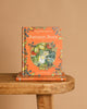 The hardcover "Autumn Story : Jill Barklem" stands upright on a wooden bench with another copy below. Its cover features an illustrated mouse among autumn harvest, berries, and leaves in the magical Brambly Hedge.