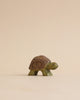 A Handmade Holzwald Turtle figurine with a detailed, patterned shell designed for imaginative play, standing against a soft beige background.