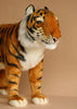 The Ride-On Tiger is a handcrafted plush toy featuring black stripes, white fur accents, and lifelike facial details, set against a plain beige background.