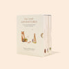 A beige colored Book Box Set titled "Our Little Adventures," featuring illustrations of a fox and a rabbit on the cover, displayed against a subtle peach background.