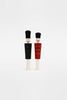 Two Wooden Soldiers, featuring uncomplicated facial features, stand together like cheerful guardians. One is dressed in black, while the other sports a red ensemble with gold highlights. Both are topped with tall black hats against a plain white background, making them ideal for adding charm to an advent calendar.