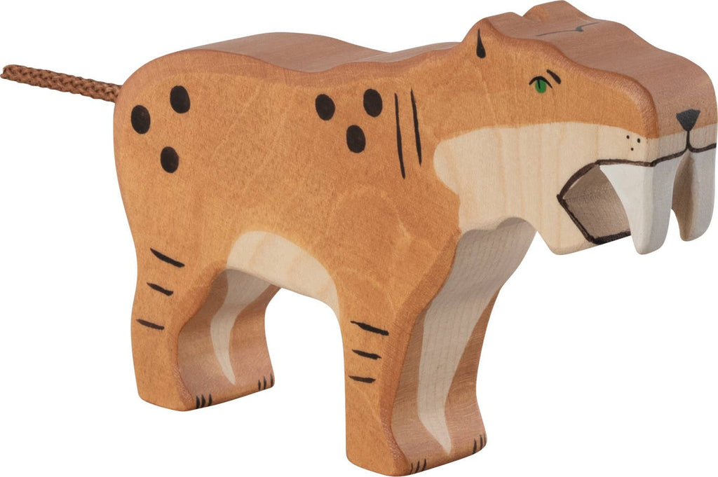 The Holztiger Saber-Toothed Tiger is a handcrafted wooden figure with painted orange and beige markings, black spots, a rope tail, and large carved fangs. Made in Europe, it features Holztiger's signature simple, stylized design.