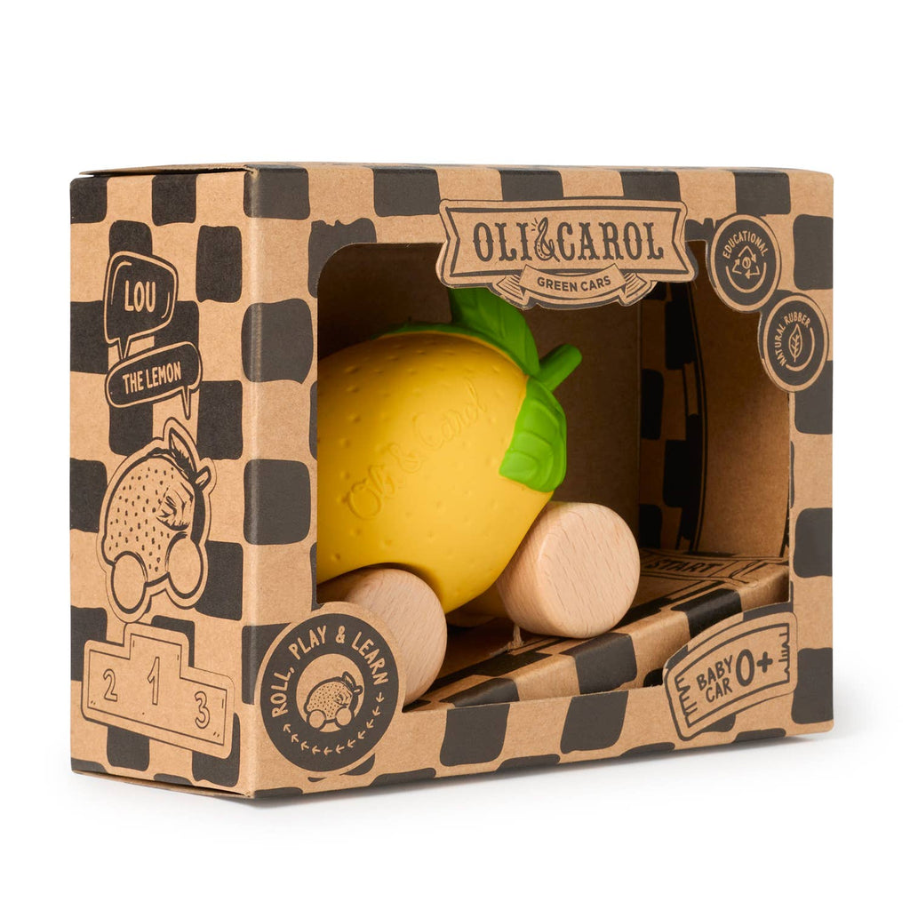 Lou The Lemon Baby Car is a wooden and natural rubber toy car shaped like a yellow lemon with green leaves. It encourages sensory play and comes in a brown checkered box labeled "Oli & Carol Green Cars" with fun illustrations.