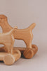 A Handmade Wooden Dog Pull Toy crafted from rich maple and beech wood, featuring wheels.