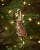 The Coral & Tusk Fox Tree Trimmer Ornament showcases an embroidered fox hanging from a green tree branch with warm white lights—ideal as a festive holiday gift or a cute addition to your tree décor.
