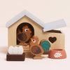 The Chicken Coop Playset is a delightful farmyard toy with a hen house, 2 wooden chickens, 3 eggs, a nest, and red food bowl. Made from FSC-certified wood, it features a heart-shaped window and blue roof.