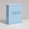 The Game of Life Vintage Bookshelf Edition, a light blue book-shaped box with minimalist gray and white accents, is designed to resemble a hardcover book—perfect for stylish display on your shelf.