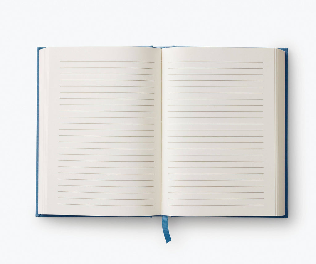 The Menagerie Garden Embroidered Journal, an open, blank lined keepsake with a blue ribbon bookmark, lays flat on a white background.