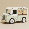 The Mobile Café Van, in pastel green and white FSC-certified wood, features a coffee cup graphic, string lights, and floral accents—ideal for imaginative play on any neutral backdrop.