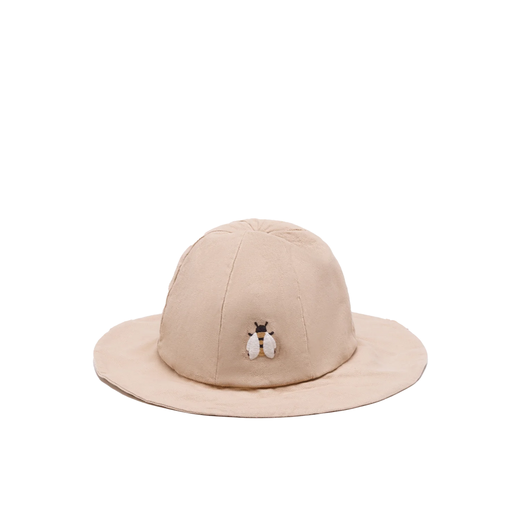 The Donsje Organic Cotton Steijn Bee Hat is a beige hat crafted from organic cotton, with a small embroidered bee on the front and a wide brim for excellent sun protection.