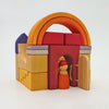 A small arched structure built from Grimm’s Building World - Desert Sand blocks, with a tiny wooden figure standing in the doorway.
