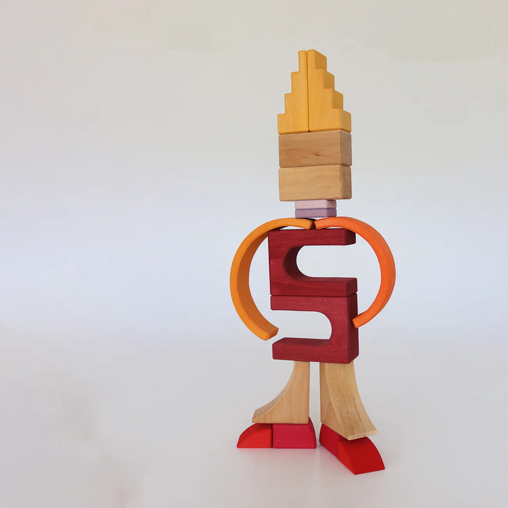 A human-like figure made of stacked wooden blocks from the Grimm’s Building World - Desert Sand set, featuring shades of yellow, orange, red, and purple, perfect for imaginative free building.