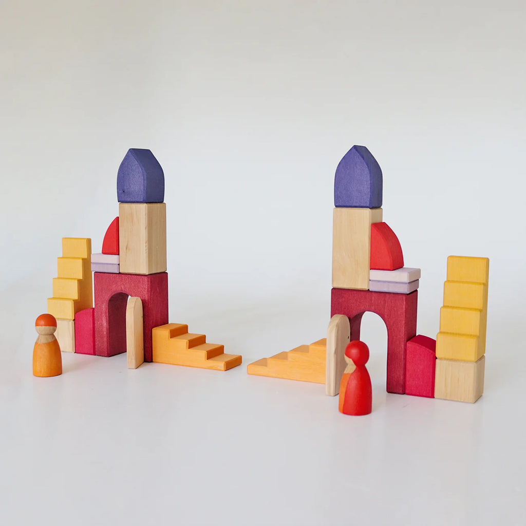 Two sets of Grimm’s Building World - Desert Sand wooden blocks arranged to form arched structures and staircases, each accompanied by a small wooden peg person for imaginative free building.