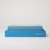 The Grimm's Building Set - Blue features colorful wooden blocks in a blue box labeled "GRIMM'S," making it an ideal toy for toddlers, shown against a plain white background.