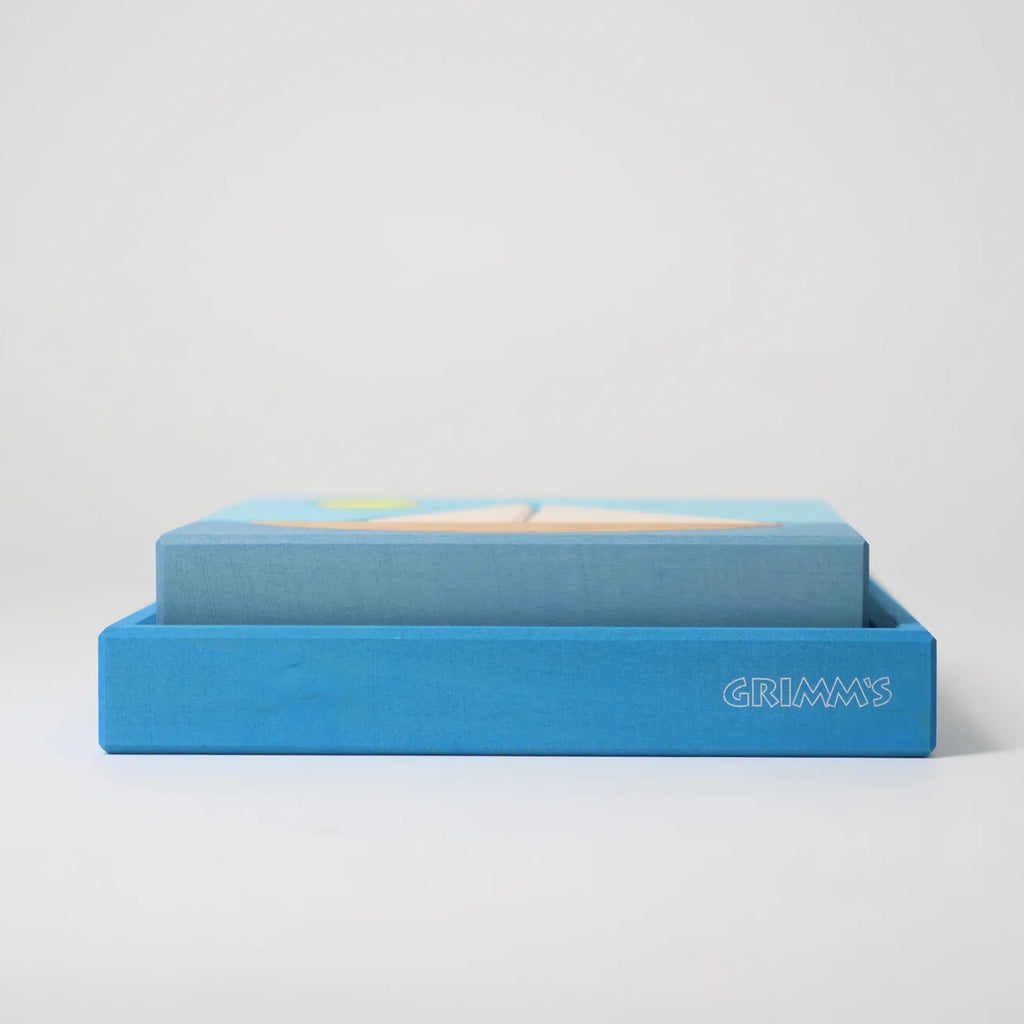 The Grimm's Building Set - Blue features colorful wooden blocks in a blue box labeled "GRIMM'S," making it an ideal toy for toddlers, shown against a plain white background.
