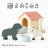The Dolls House Pet Set includes wooden dog and cat figurines, a small bowl, and a blurred doghouse—perfect for imaginative play. Icons show creativity, coordination, social skills, and imagination. Text below reads: "Hand Made with Love.
