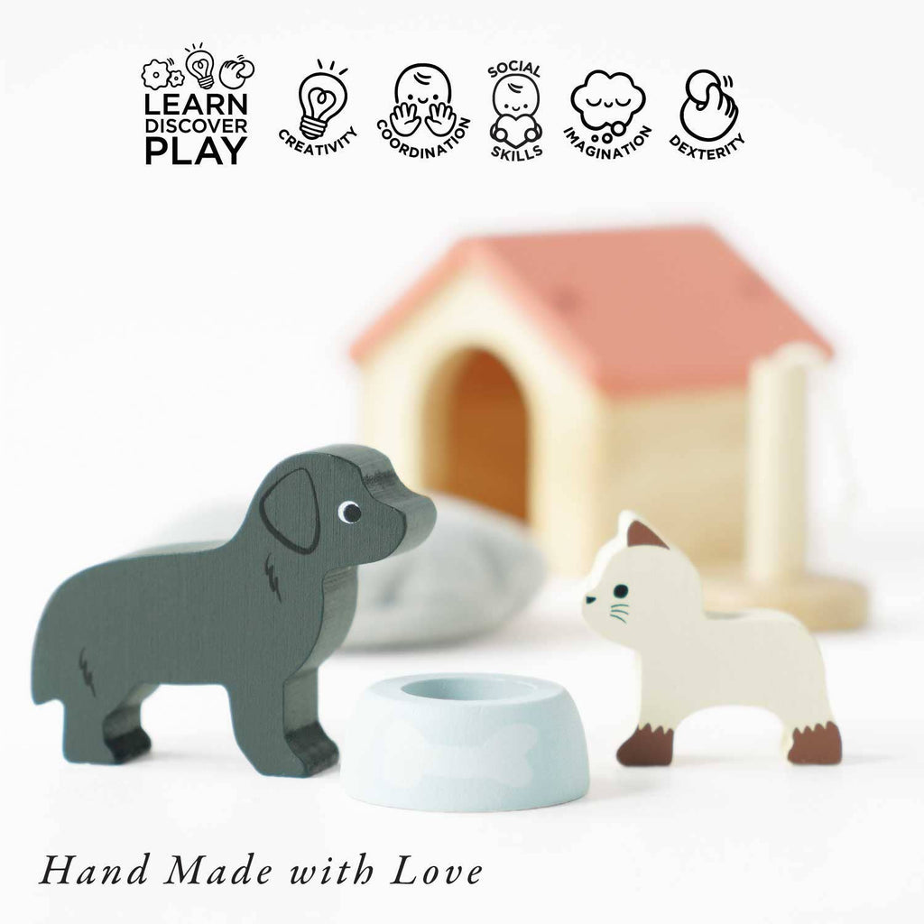 The Dolls House Pet Set includes wooden dog and cat figurines, a small bowl, and a blurred doghouse—perfect for imaginative play. Icons show creativity, coordination, social skills, and imagination. Text below reads: "Hand Made with Love.
