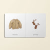 On the left, a beige knitted sweater is displayed. To the right are matching beige mittens with pom-poms, ideal for a baby's playdate. Both are set against a white background with the label "Our Little Library Vol. 2" underneath.