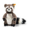 The Steiff Pedro Raccoon 9" is a plush toy with brown and white fur, a white belly, black paws, a fluffy striped tail, and a yellow tag in one ear, shown sitting upright against a white background.