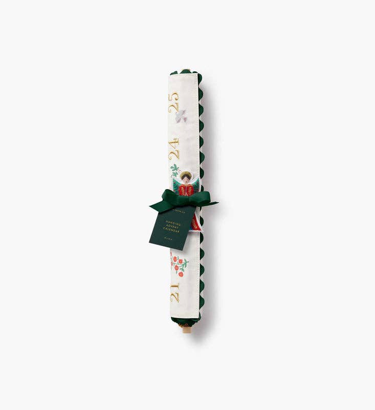 A Nativity Embroidered Hanging Advent Calendar, rolled up and tied with a green ribbon with a hanging tag, featuring embroidered numbers and a nativity scene.