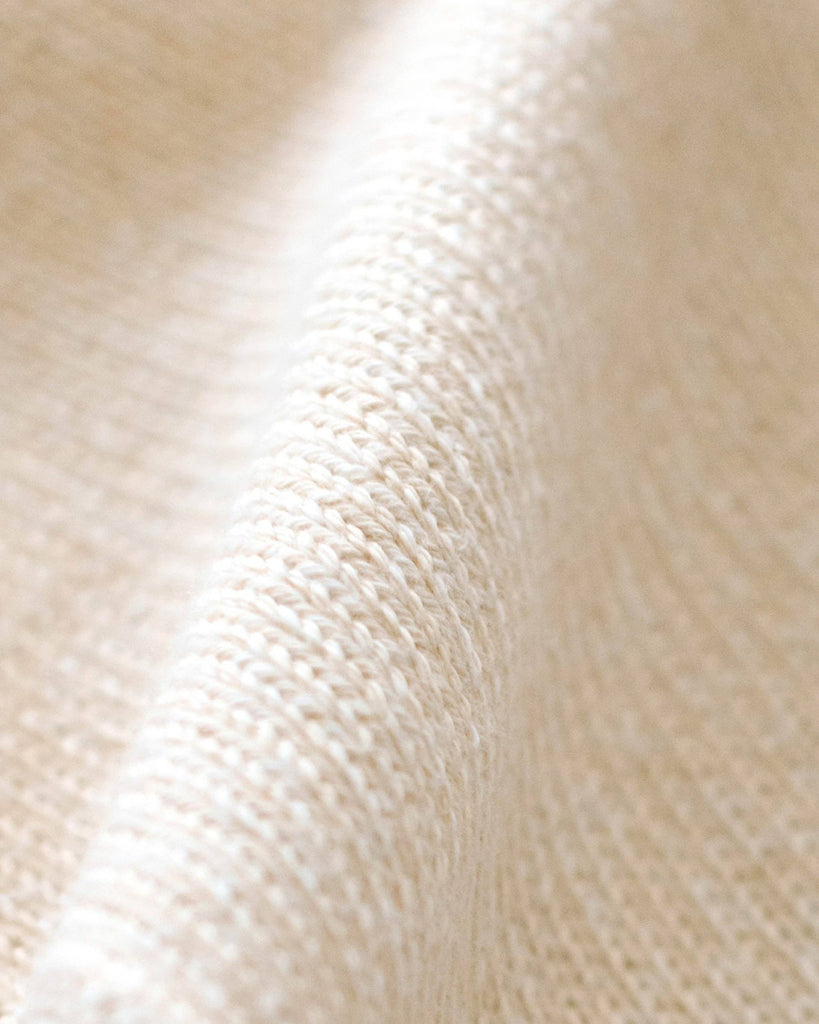 Close-up of the Cuddle + Kind Organic Cotton Baby Bunny Lovey in Oatmeal, featuring textured, off-white woven fabric with a diagonal ridge—ideal for an heirloom-quality lovey or hand-knit baby blanket.