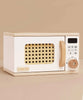The Wooden Microwave (ships in one week) is a small, sustainable wood toy with a white body, natural handle and knob, woven rattan-look window, and a control panel featuring printed buttons and a digital display—perfect for play kitchens.