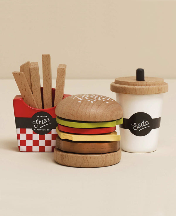 The Gourmet Hamburger Set includes a burger with layered toppings, fries in a red container, and a "Soda" cup—all made from sustainable wood—ideal for any play kitchen (ships in one week).
