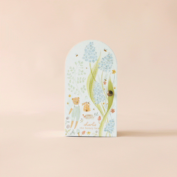 Inspired by fair trade artistry and Peruvian handmade charm, this door features a drawing of Cuddle + Kind Tiny Charlie the Honey Bear with flowers.