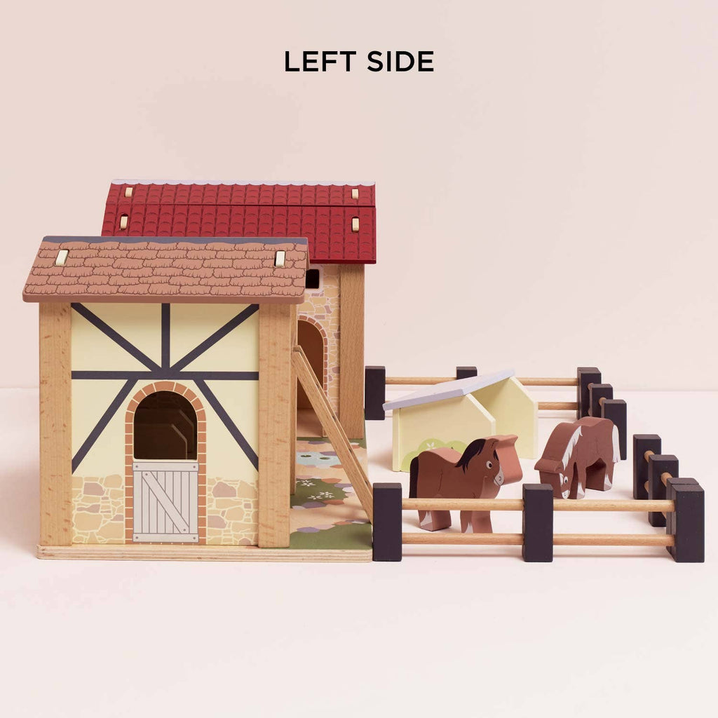 The Wooden Farmyard Stables is a FSC-certified wooden playset with a red roof, fenced area, two toy horses, and shelter, labeled "LEFT SIDE" above for engaging small world play.