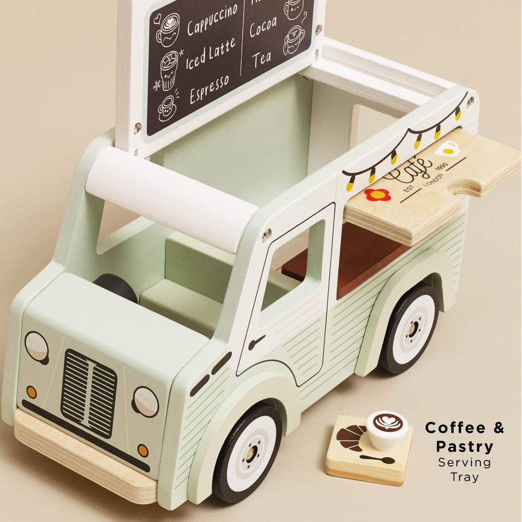The Mobile Café Van is a vintage-style toy coffee truck with a menu sign, pull-out tray featuring coffee and pastry illustrations, and wooden coffee-themed pieces for play. Made from FSC-certified wood. Tray text: “Coffee & Pastry Serving Tray.”.