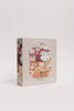The Beneath the Branches 200 Piece Puzzle features a whimsical treehouse scene with animals and people, soft pastel packaging, and matte, recycled pieces. Perfect for ages 7+, it promises eco-friendly fun.