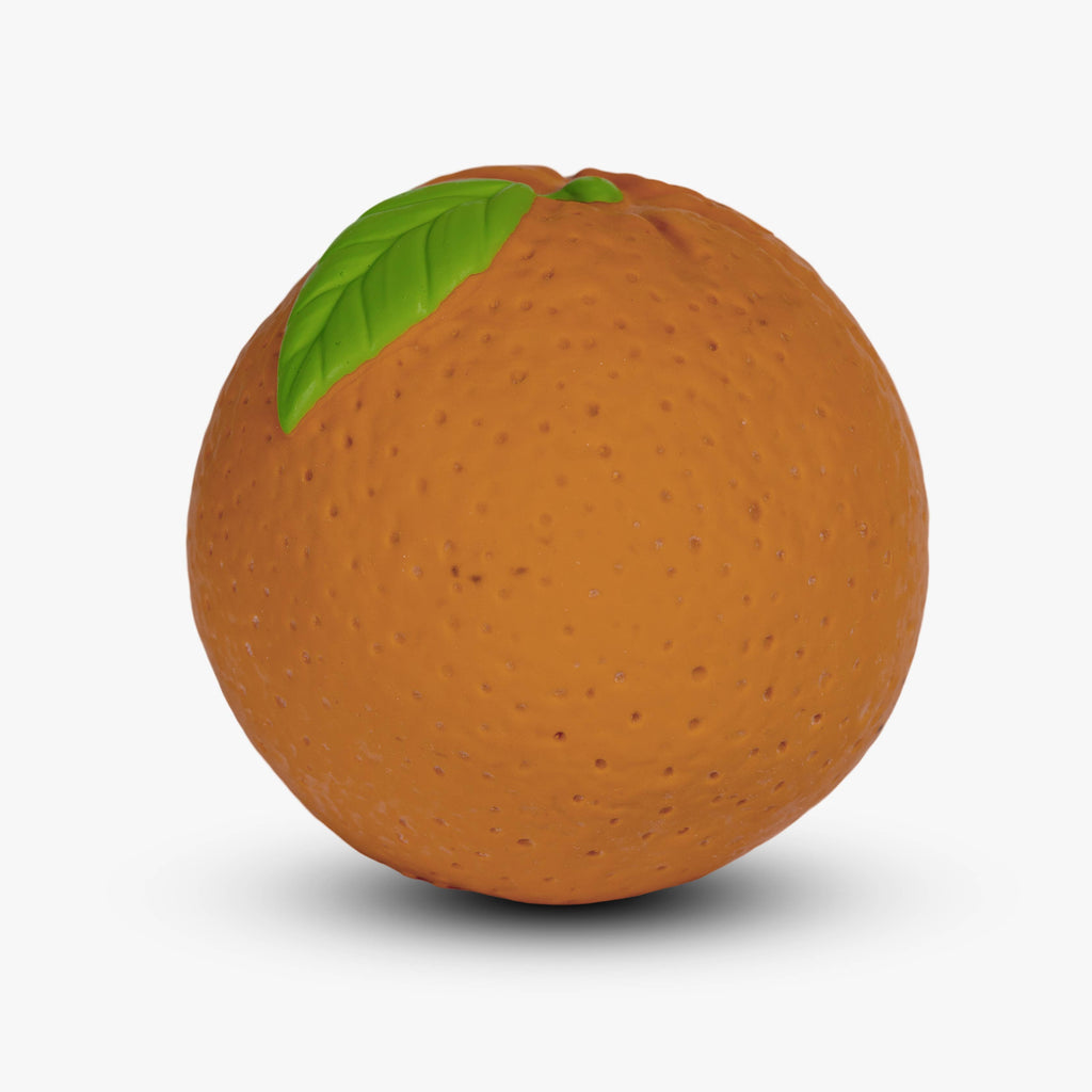 The Orange Baby Ball, with its round, orange shape, dimpled texture, and single green leaf on top, sits against a plain white background and resembles a fruit.