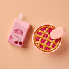 A Tiny Tummies Set - Cherry Pie Bowl and Juice Box features an interactive juice box next to a toy cherry pie in a magical pie bowl with a serving spoon.