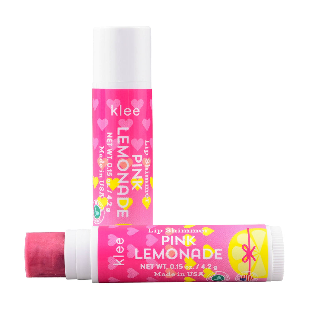 Two tubes of Pink Lemonade lip shimmer from the Klee Naturals Deluxe Makeup Kit - Unicorn Cloud Fairy, one standing upright and one lying horizontally with its cap off to show the pink product.