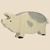 The Holtztiger Boar, handcrafted from maple and beech wood with a light cream body, gray markings, heart-shaped spot, black hooves, and a simple face—classic HOLZTIGER—ships in one week. Shown against a beige background.